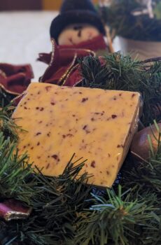 a wedge of cranberry cheese arranged on a christmas wreath