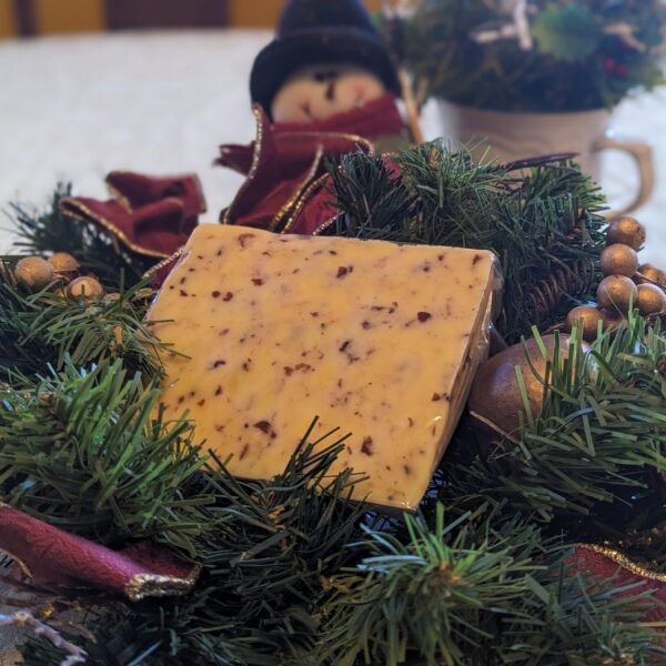 a wedge of cranberry cheese arranged on a christmas wreath