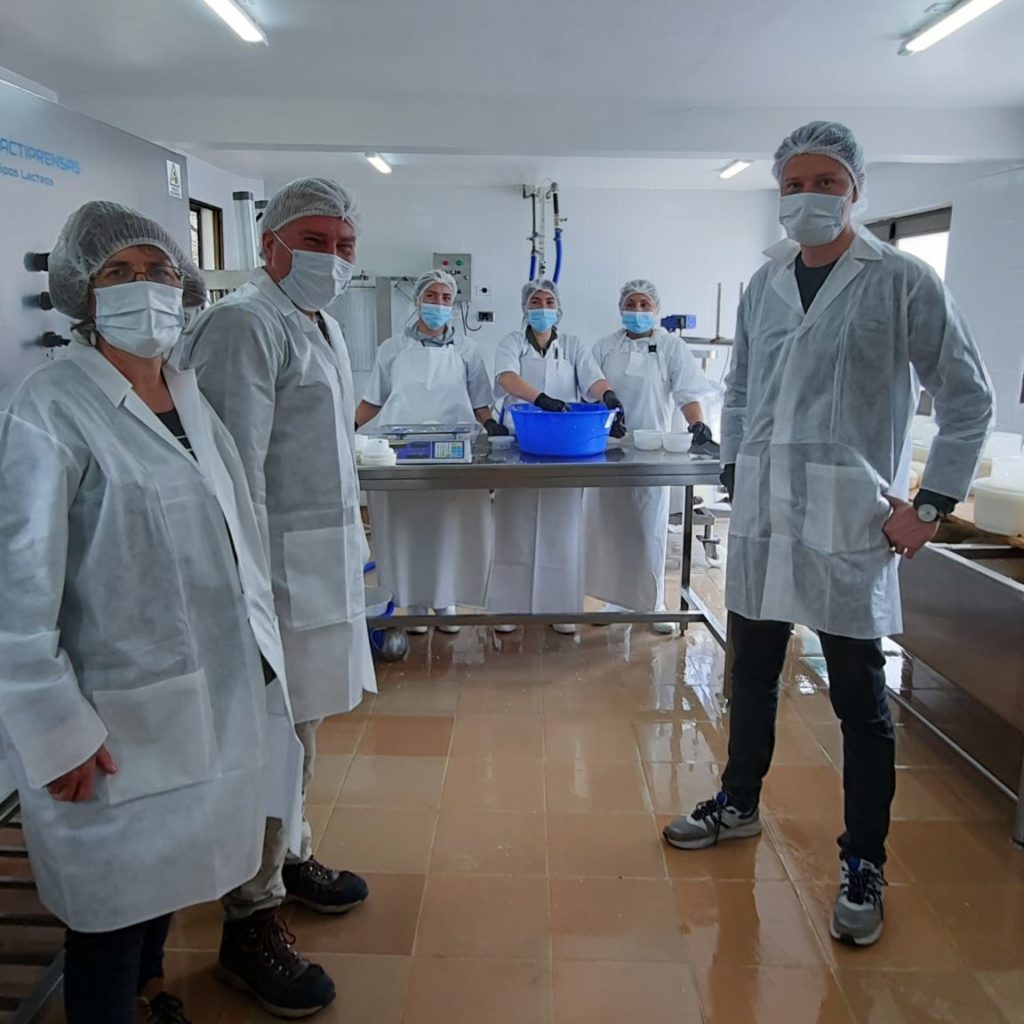 Several people inside a Colombian cheesemaking facility