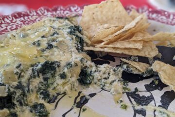 Spinach Artichoke Dip served on a plate with tortilla chips