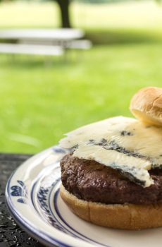 a beef patty topped with a slice of blue cheese