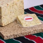 a wheel and wedge of hot pepper cheese