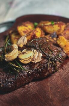 a sirloin steak served with roasted potatoes