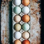 a dozen multi-color eggs on tray