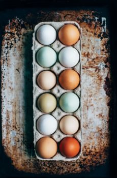 a dozen multi-color eggs on tray