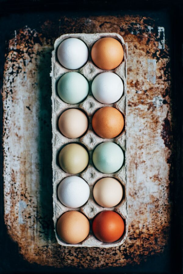 a dozen multi-color eggs on tray