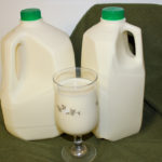 a gallon and half gallon jug of raw milk